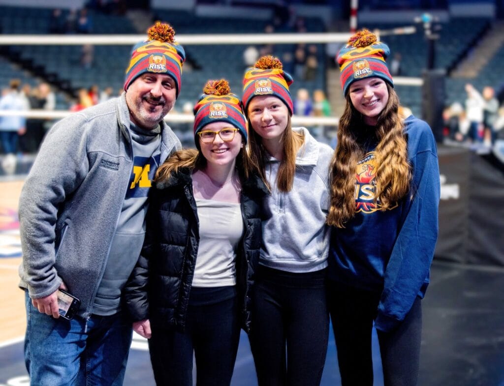 Fans wearing custom Roadie® pom beanies at a hockey game